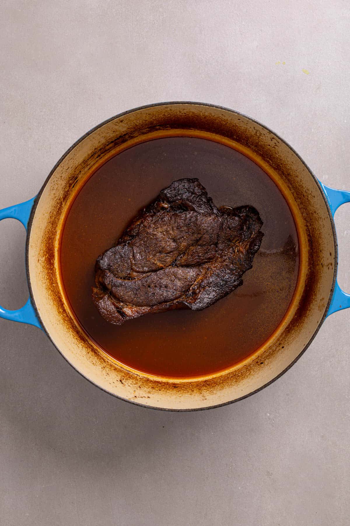 A Dutch oven with braised chuck roast whole.