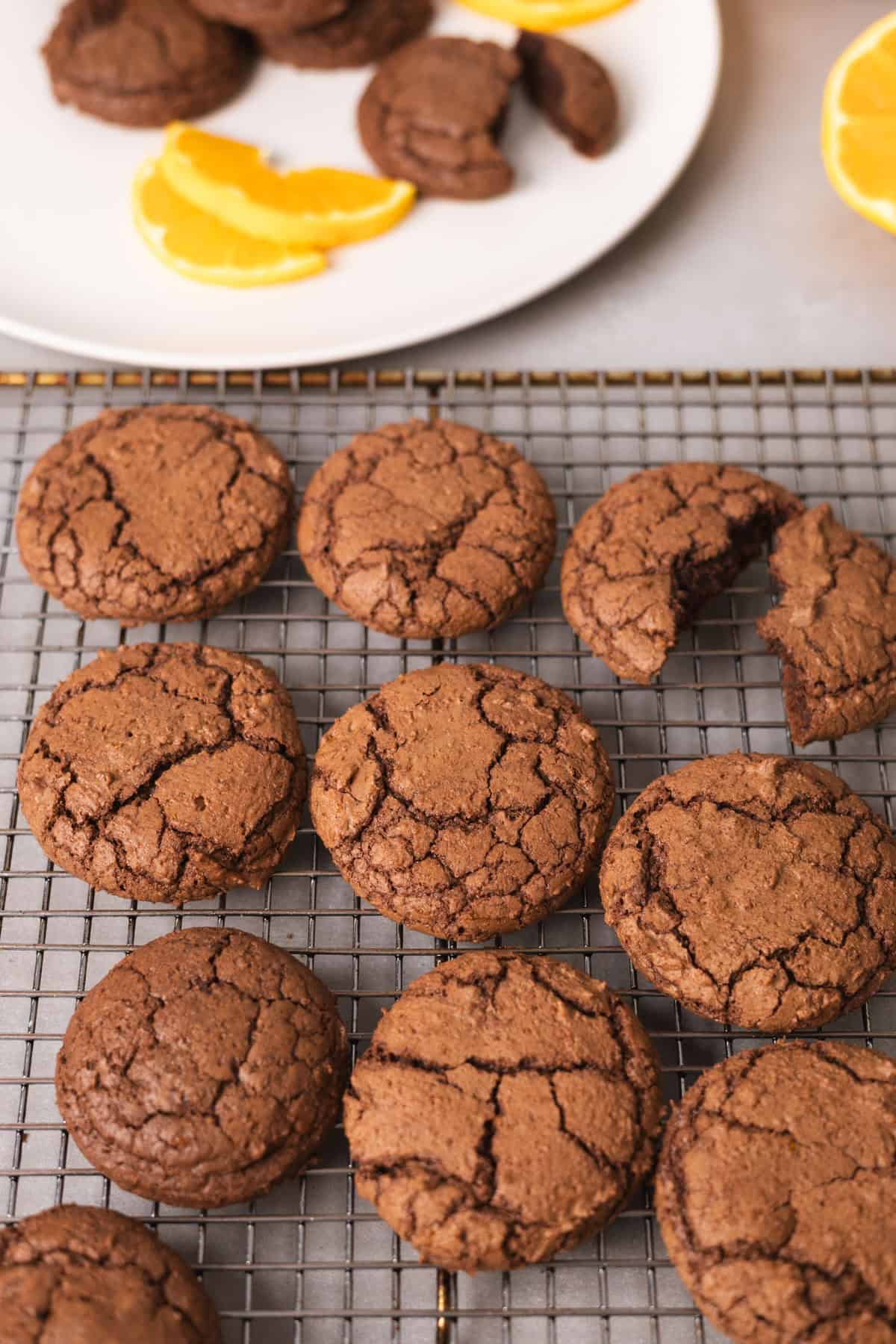 Chocolate and orange cooking cooling on a wire rack with slices of orange garnish.