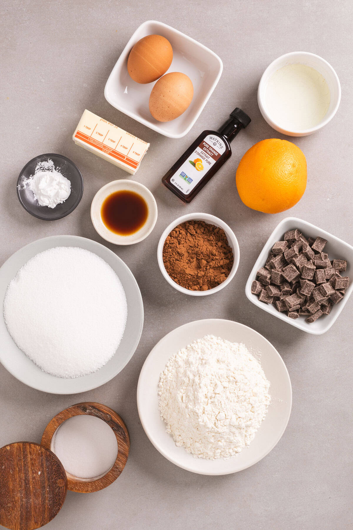 Ingredients for chocolate and orange cookies on a gray table.