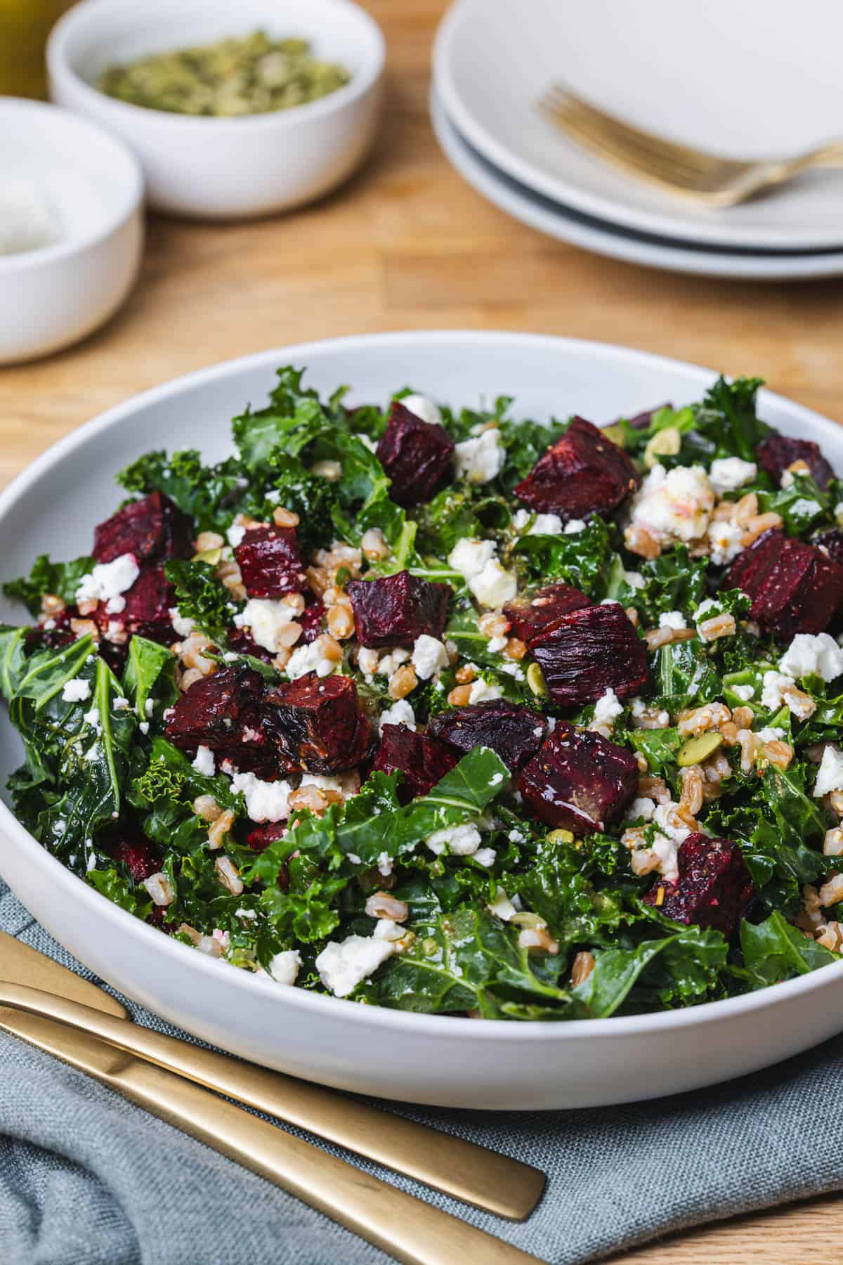 A close-up of a white bowl with kale and beet salad.